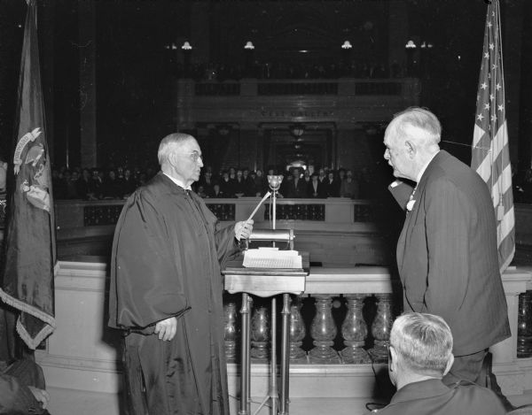 Chief Justice Marvin B. Rosenberry, left, of the Wisconsin Supreme Court, administering the oath of office to Governor Walter S. Goodland in the Wisconsin State Capitol rotunda at the inauguration ceremony for Governor Goodland's third term.