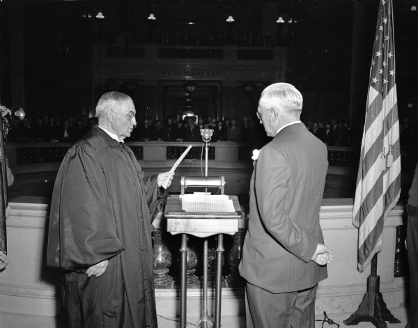 Chief Justice Marvin B. Rosenberry, left, of the Wisconsin Supreme Court, administering the oath of office to Lieutenant Governor Oscar Rennebohm in the Wisconsin State Capitol rotunda.