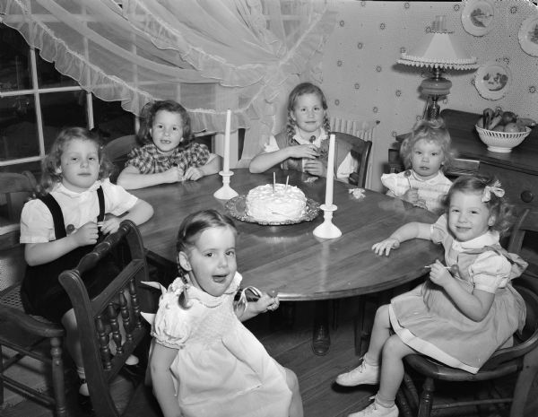 Six young children seated around a table at a birthday party. Taken for Lawrence Fitzpatrick, managing editor of the "Wisconsin State Journal".