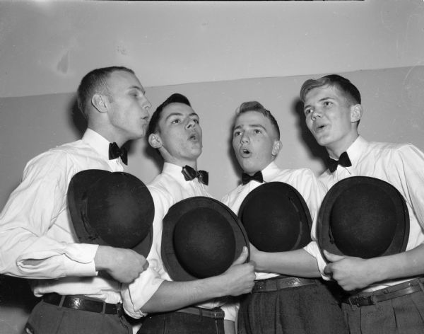 Group portrait of a high school barbershop quartet.