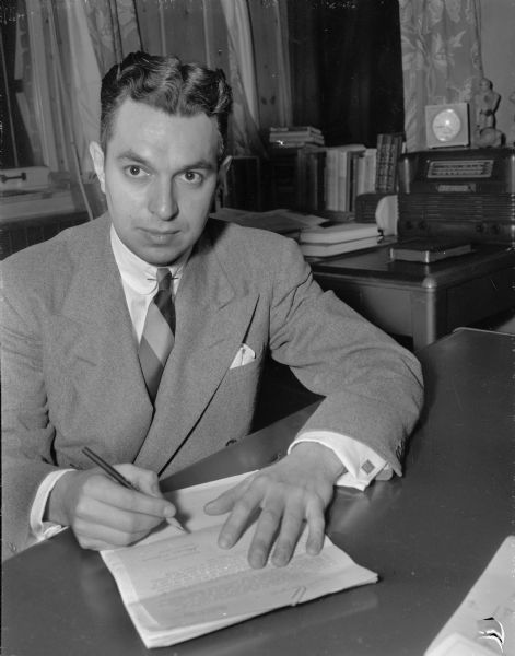 Portrait of a young man, either Richard C. Smith or a Mr. Johnson, sitting at an office desk signing a formal document.