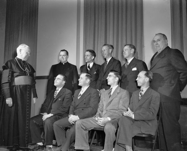 Charter members of the Holy Name Society, Our Lady Queen of Peace parish, at their swearing-in ceremony. Pictured seated from the left are: Louis Fiore, society president; Herbert Zimmerman, secretary; Gilbert Rowley and Alver Fleury, vice-presidents.  Standing from the left are: Bishop William P. O'Connor; Rev. Bernard Doyle; Richard Reese, treasurer; Robert Welch, marshal; and Joseph Fagen and Mathew Mueller, delegates.