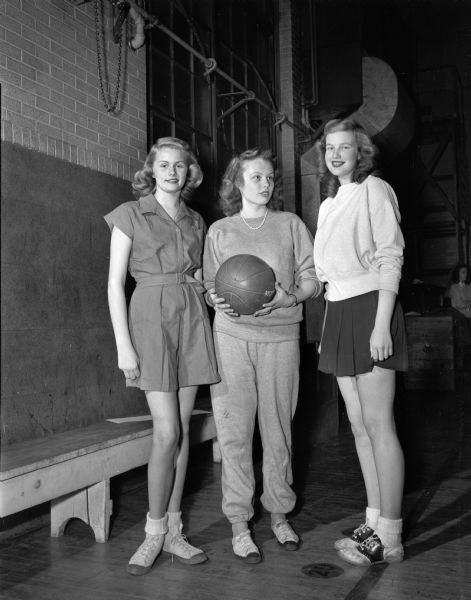 Group portrait of three West High School girls practicing for a basketball contest. From left to right are Betty Christofferson, Pat McCann, and Phyllis Bakker.