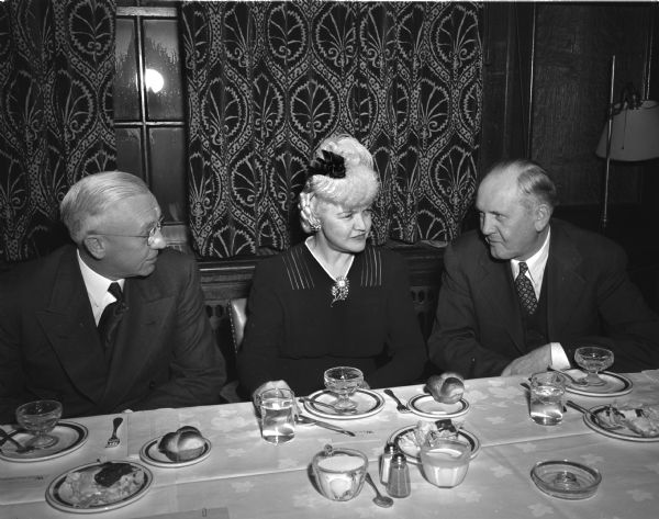 98th University of Wisconsin Founder's Day dinner at the Memorial Union where an announcement was made of a campaign to raise five million dollars for the improvement of the lower campus at the University of Wisconsin-Madison. Left to right: Lieut. Governor Oscar Rennebohm; Mrs. Oscar (Mary) Rennebohm; and John Berge, Secretary of the Wisconsin Alumni Association.