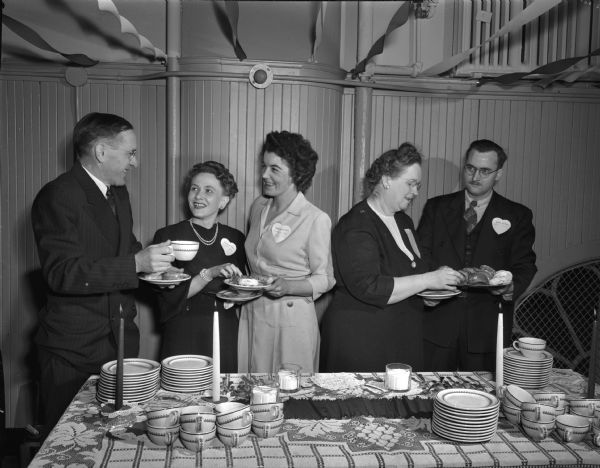 Labor Union party sponsored by the YWCA Industrial Committee, with many activities. People are gathered around the buffet table. l to r: Eldon Morris, Scanlan-Morris union, Eula Bunce, Gisholt union, Marion White, Ray-O-Vac union, Esther Schwartz, chairman of the YWCA's industrial committee, and Frank Bunce.