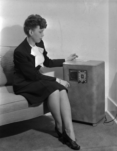 Coin operated hotel radio operated by a woman.