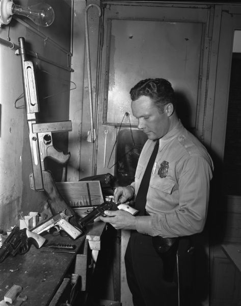 Police Officer Robert O'Brien showing guns he carved.