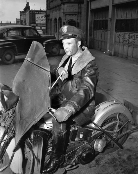 Robert O'Brien, police officer on motorcycle, in front of Police Station.