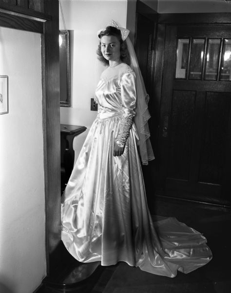 Full-length portrait of Nancy Burlingame Fowler, daughter of Mr. & Mrs. Dwight S. Fowler, in her wedding gown.  She became the wife of Chester E. Rieck Jr. of Oak Park Illinois on March 15, 1947.