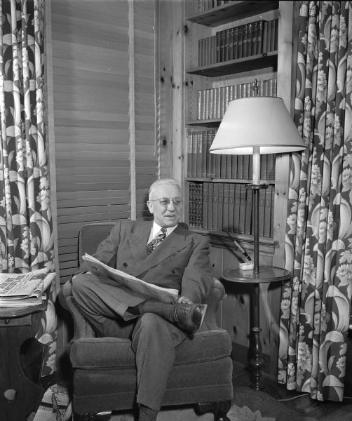 Governor Oscar Rennebohm relaxing in the library of his Maple Bluff home, 201 Farwell Drive.