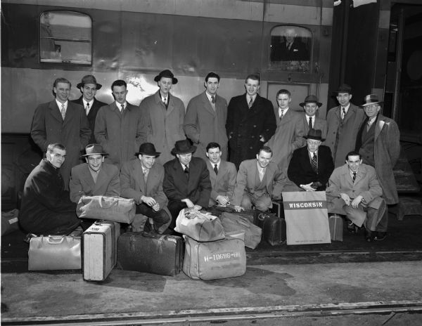 Group portrait of University of Wisconsin Big Nine basketball championship team, at the train depot, before departing for New York for the NCAA tournament. Group includes the coach, Harold E. "Bud" Foster, and trainer, Walter Bakke.