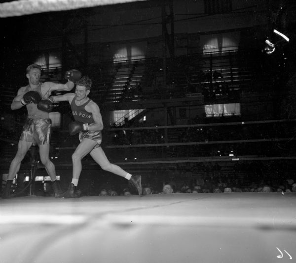 Herb Carlson (left) of Idaho and Stan Wheatley of the United States Merchant Marine Academy, boxing at the National Collegiate Athletic Association tournament held at the University of Wisconsin-Madison Field House.