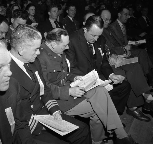Four members of the NCAA committee checking score cards from the referee and two judges following a bout at the NCAA National Boxing Tournament at the University of Wisconsin-Madison Field House. From left are: I.F. Toomey, California Aggies; Commander John Merriman, Jr., Coast Guard Academy; Col. John Harmony, U.S. Military Academy; and Thomas Carruthers, University of Virginia.