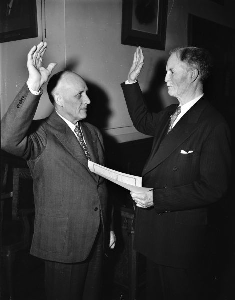 Wildon F. Whitney taking the oath of office as a member of Public Service Commission from Secretary of State Fred Zimmerman.