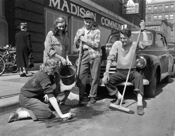 Youth council spring clean-up committee cleaning the street in front of the Madison Community Center. Left to right: Rebecca Wilson, Martha Truog, George Stebbins, and George Koehler.