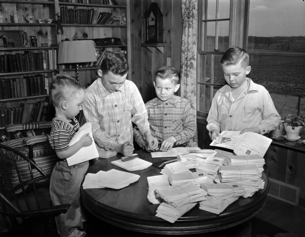Four sons of Mrs. Ralph Jacobs, Verona, stuffing envelopes at home for the Dane County American Cancer Society drive. Their names are, from left: Paul, 2 1/2, Herbert, 12, David, 8, and Austin, 10.