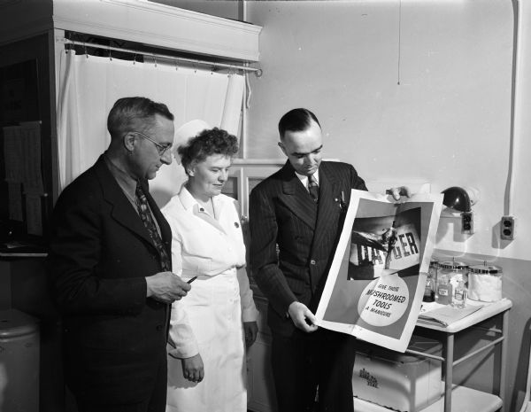 Public Health Nursing Week. Miss Agnes Moroney of the third district unit of Wisconsin State Organization of Public Health Nursing and supervising nurse at the Gisholt Machine Co., discusses the company's accident prevention program with John Wrage, left, safety director of the Gisholt Co., and Allen Stein, chairman of the safety committee.