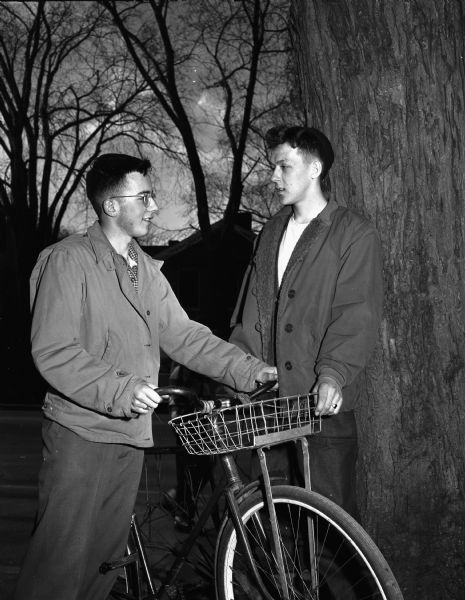 Two teen-age boys, Jerry Lenz, left, and Bob Consigny, with bicycle, are shown discussing Bicycle Safety Week which the Madison Youth Council sponsors.