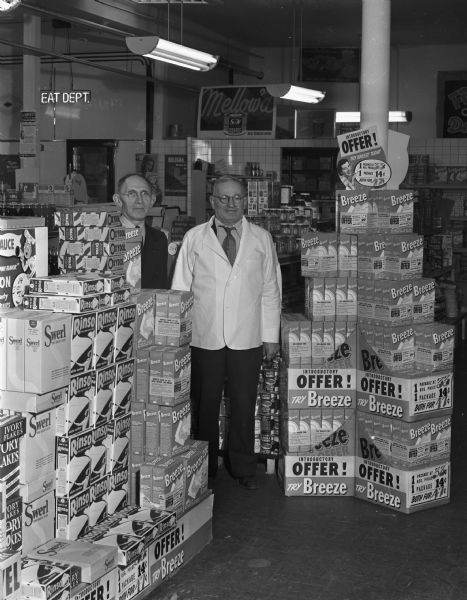 Display of "Breeze" laundry detergent in a grocery store with two men.