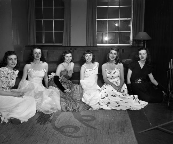 Group portrait of the "court of Honor" for the University of Wisconsin Military Ball. Pictured left to right: Suzanne Johnson, 26 Breeze Terrace, representing Kappa Kappa Gamma sorority; Barbara Ross, Denver, Colorado, representing Tower View House; Gloria Damon, Wausau, Anderson House; Eileen Freud, Lake Kegonsa Cochrane House, and Lois Lauridsen, 6120 Thorton Avenue, representative of Delta Delta Delta sorority.