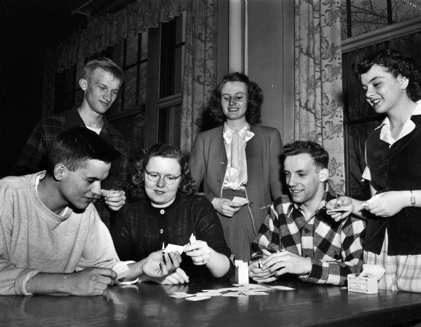 Group of East High School senior students exchanging "class cards" in preparation for commencement. Pictured left to right: John Collins, Paul Hoenk, Nancy Melby, Connie Oliver, Wayne Blossom, and Phyllis Lansing.