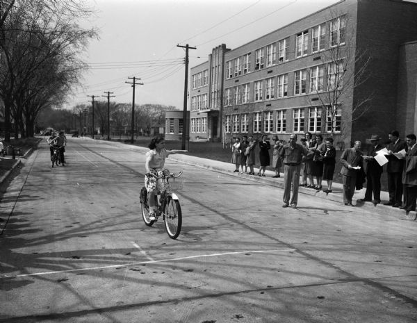 Marquette School students being tested for riding skills in front of the school, 510 South Thornton Avenue. The testing is along Spaight Street.