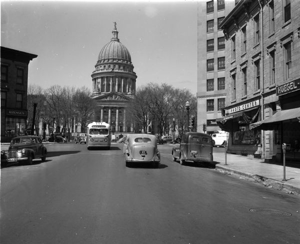 Wisconsin State Capitol building from King Street. Commercial businesses  are Kresge's, 27 East Main Street, and Bergmann Prescription and Photo Center, 102 King Street.