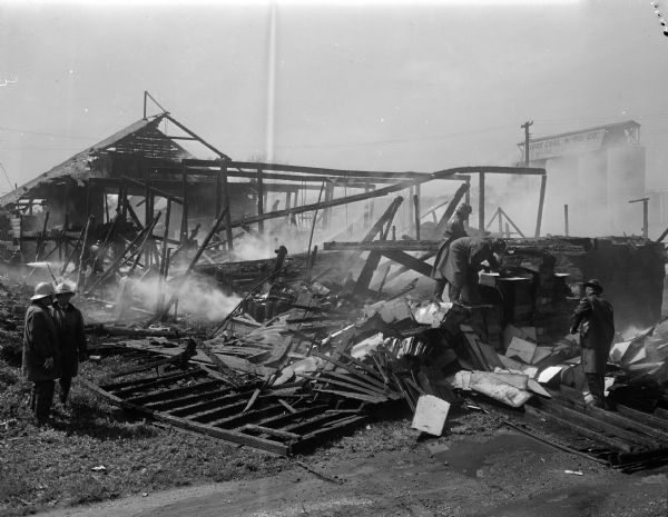 Firemen at the scene of the Doyon Lumber Company fire, 638 West Mifflin Street. The Fiore coal silos are visible in the background.