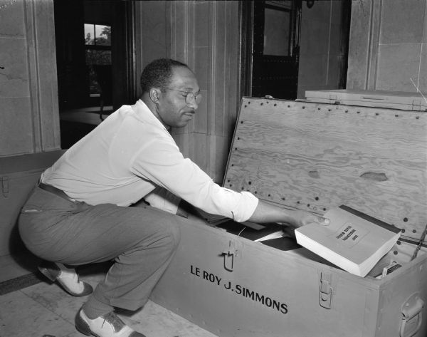 LeRoy J. Simmons (D.-Milwaukee) filling his "plunder box" with copies of statutes and bills, at the end of the State Legislative term.