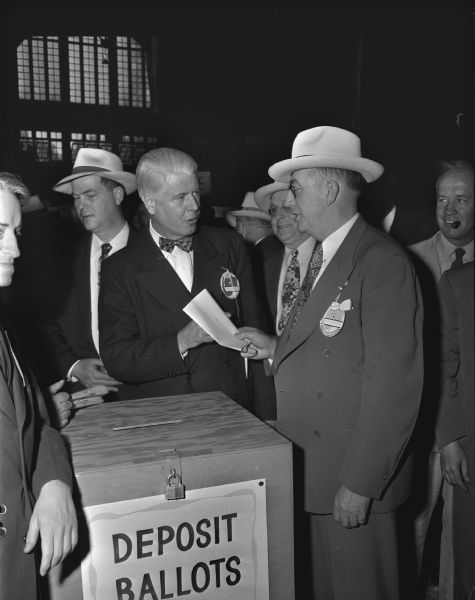 Assembly Speaker, Donald McDowell, casting a straw vote for U.S. President. George Greene, editor of Waupun Leader News, supervising the vote.