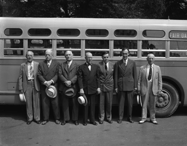 The Madison Bus Company's new 45 seat bus shown with company officials and former employees formerly associated with the Madison Railways Company, the predecessor of the Madison Bus Company. Those pictured and the dates they became associated with the Madison transportation system are, left to right: Matt Stumpf, 1890 (retired); William Neff, 1894 (retired); Henry Milbrook, 1898, office employee; Dudley O. Montgomery, 1905 vice president and general manager; John Holcomb, 1933, assistant manager; Bill Straub, 1934, secretary and treasurer; William Devine, 1936, president.