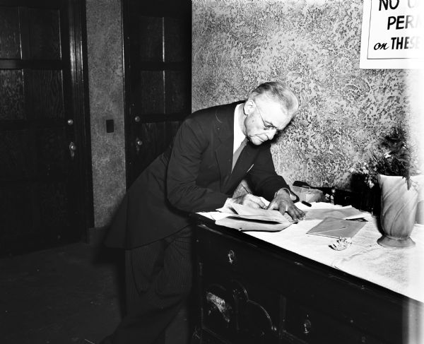 Unidentified man signing the marriage document for the Shirley Steinhauer and William Sundquist wedding.