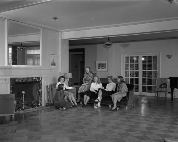 Six women sitting by the fireplace in the parlor at Elizabeth Waters Dormitory on the campus of the University of Wisconsin-Madison.