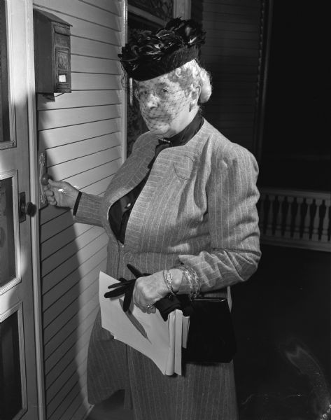 Emma Teckemeyer, ringing a doorbell, is a long-time volunteer for the Community Chest Campaign.