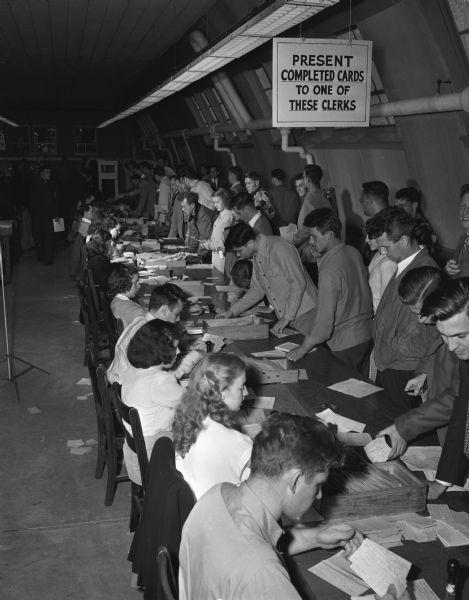 Clerks signing up students at tables inside a Quonset hut on the University of Wisconsin-Madison campus during registration week.