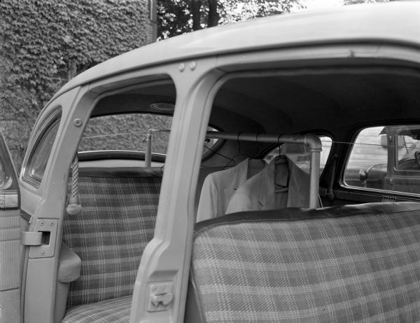 Clothes pole mounted in the back seat of an automobile. The photograph was taken for Meek's Auto Body Company, 1119 Williamson Street.