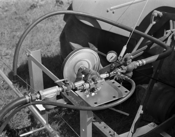 Close-up of a spray bar connection that was fabricated by Kupfer Foundry and Iron Works, Inc., 101-149 Waubesa Street, on a tractor. 
