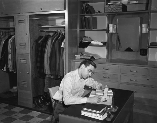 University of Wisconsin student Louis Stieghorst, Wauwautosa, seated at a desk in Slichter Hall, 625 Babcock Drive. The dorm was named for Dr. Charles Sumner Slichter, Dean of the Graduate School, at the University of Wisconsin-Madison campus.
