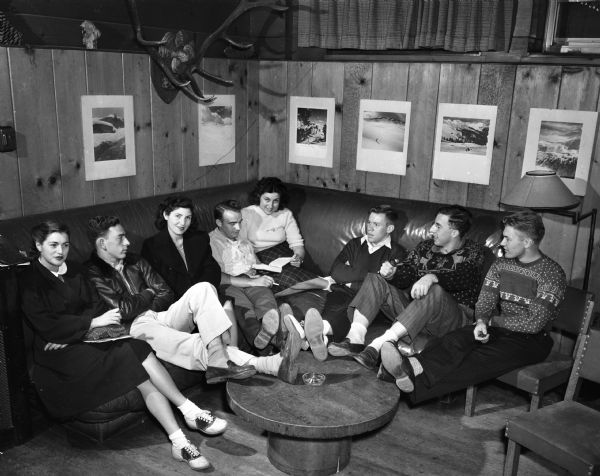 Eight University of Wisconsin-Madison Hoofers Club members lounging in their club room at the Memorial Union.