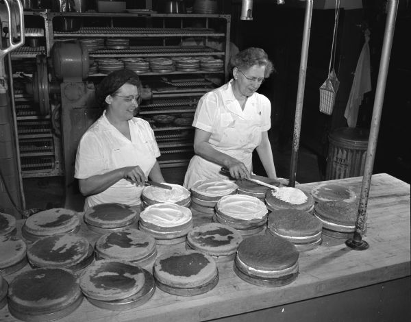 Shown icing cakes in the kitchens of the University of Wisconsin-Madison Memorial Union are Mrs. Wilma Laufenberger, left, and Mrs. Ursula Baltes.