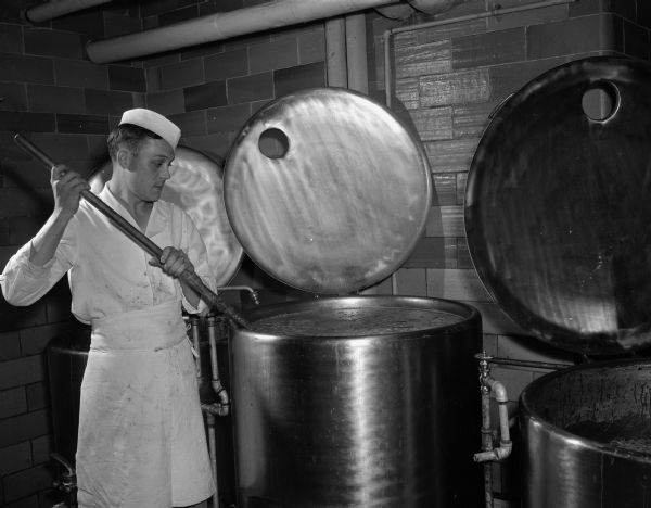 Alver Harris stirs some of the soup stock in one of the huge kettles at the Memorial Union, University of Wisconsin-Madison.