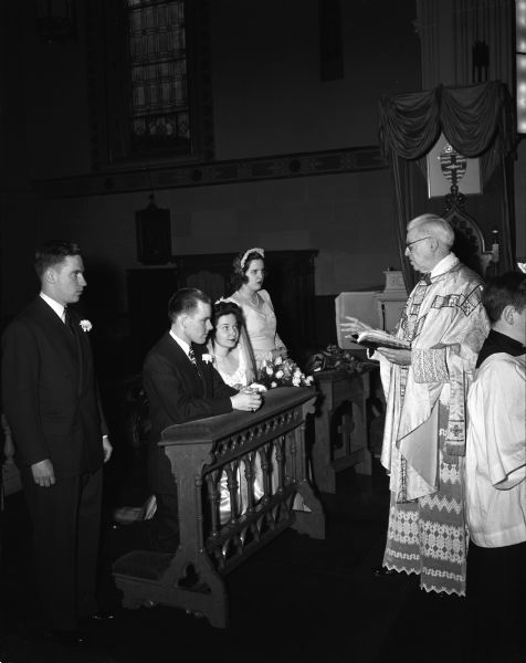 John E. Skelton and Kathleen Hacker wedding ceremony at the altar of St. Raphael's Church, with the Rt. Reverend William Mahoney officiating, the maid of honor, B'ann Blied, and best man, John Mountain.