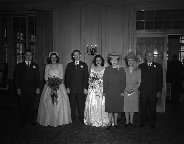 John E. Skelton and Kathleen Hacker wedding party receiving line at the Madison Club with the bride and groom, their parents, Mr. and Mrs. George Hacker, Mrs. Edward J. Skelton, and the maid of honor, B'ann Blied, and best man, John Mountain.