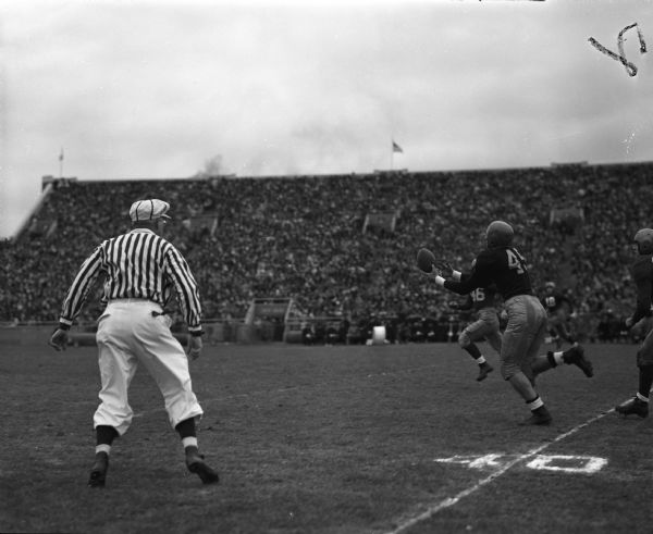 University of Wisconsin Homecoming football game at Camp Randall. Wisconsin's Gene Evans (46) is racing in to stop a reception by Iowa player, Harold Schoener.