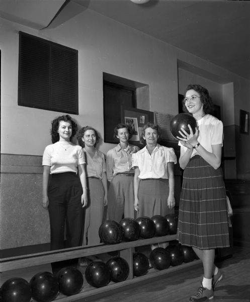 Five women at Lathrop Hall, 1016 University Avenue, participating in the recreation program for faculty and clerical staff at the University of Wisconsin-Madison.  Shown left to right are Rosemary Hummer, Gladys Meier, Elna Lombard, and Lydia Shafer watching Florence Guzniczak start to bowl.