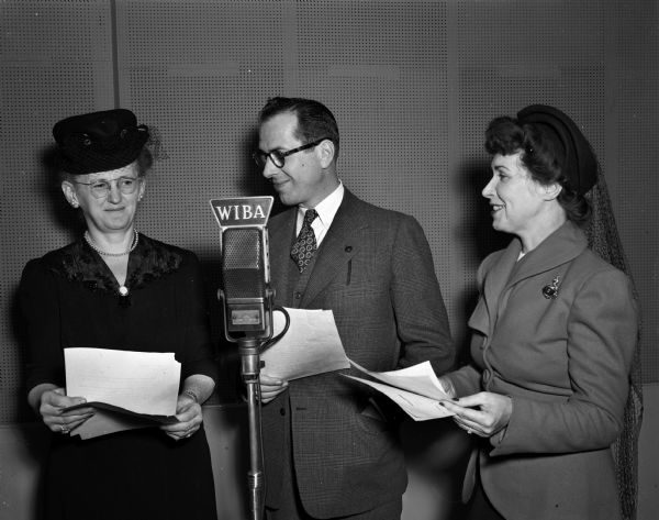Two women and a man standing next to a microphone at the WIBA radio studio. (Contest winner?)