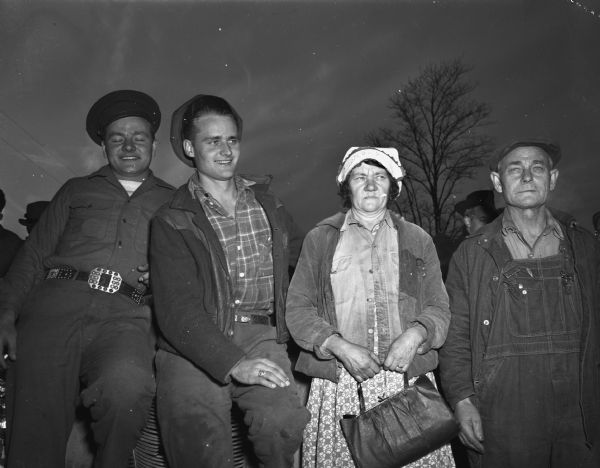 The family whose farm was the location where the alleged murderers were captured is pictured left to right: Anthony Pomputis, a friend of Robert Winslow, (the slayers sought out Anthony and admitted the killing), Alfred Pomputis, Mrs. Peter Pomputis, and Peter Pomputis.