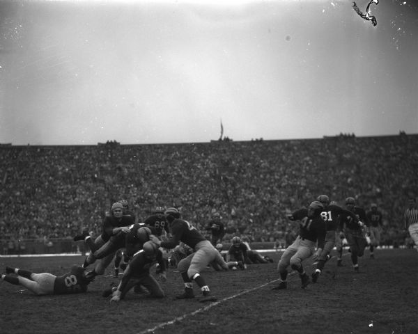 Earl "Jug" Girard carrying the ball into the Michigan line during the Wisconsin-Michigan football game at Camp Randall Stadium.