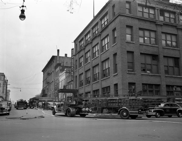 Fire truck at the corner of S. Carroll and W. Doty Streets putting out a fire in the Wisconsin State Journal building, 115-23 S. Carroll Street. Other buildings on the street, looking north right to left, are 115 S. Carroll Street, Brock Engraving, and Arthur Vinje on the 4th floor; 113 S. Carroll Street, Master Blue Print Co.,; 111 S. Carroll Street, Roick & Opsahl lawyers and Zevnik Real Estate; 109 S. Carroll Street, Wisconsin Engraving Co.; and 29 W. Main Street, Bleid Building with Wisconsin & Felton Sporting Goods Co. on the ground floor.