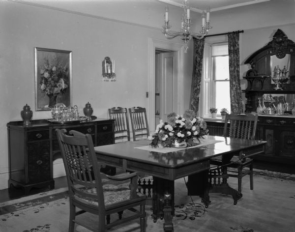 Interior view of the Wisconsin Governor's residence, 130 East Gilman Street. The dining room is furnished with walnut furniture. Over the buffet is one of the many paintings from the famous collection of General Julius White for whom the house was built in 1854. The house became the official governor's residence in 1885.